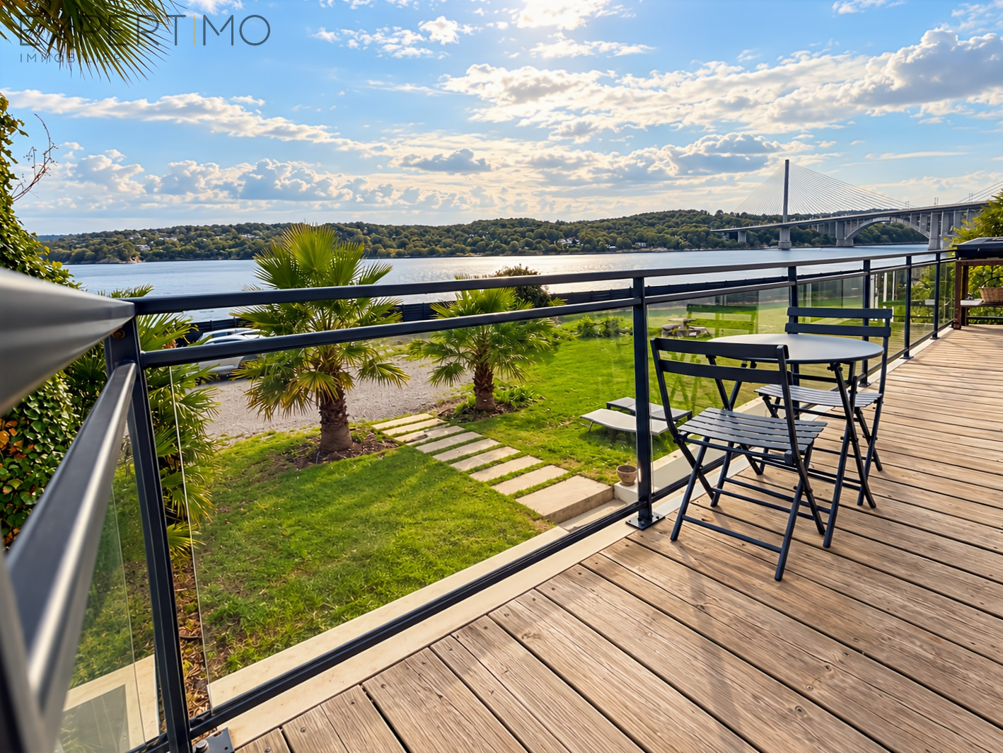 Contemporary property in Le Relecq-Kerhuon Wooden terrace with views of Brest harbor and the bridge, surrounded by greenery.