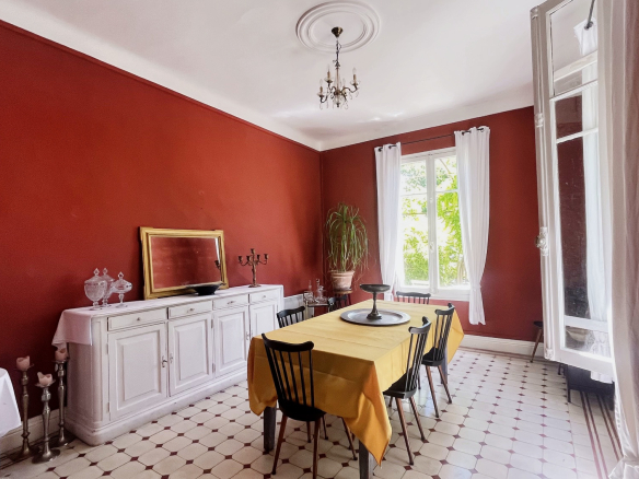 Interior of a dining room with red walls and a table for six people, L'Isle-sur-la-Sorgue.