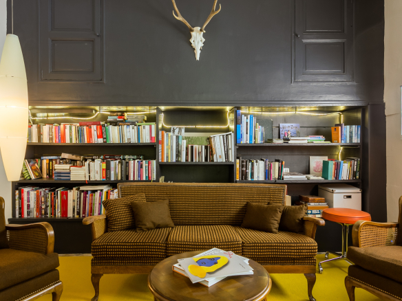 Interior of a bastide with a living room, library and armchairs, in L'Isle-sur-la-Sorgue.