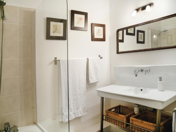 Modern bathroom with shower and sink, decorated with picture frames on the wall.