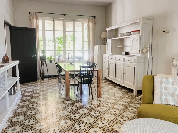 Interior of a renovated bastide with living room, dining room and kitchen, decorative tiling.