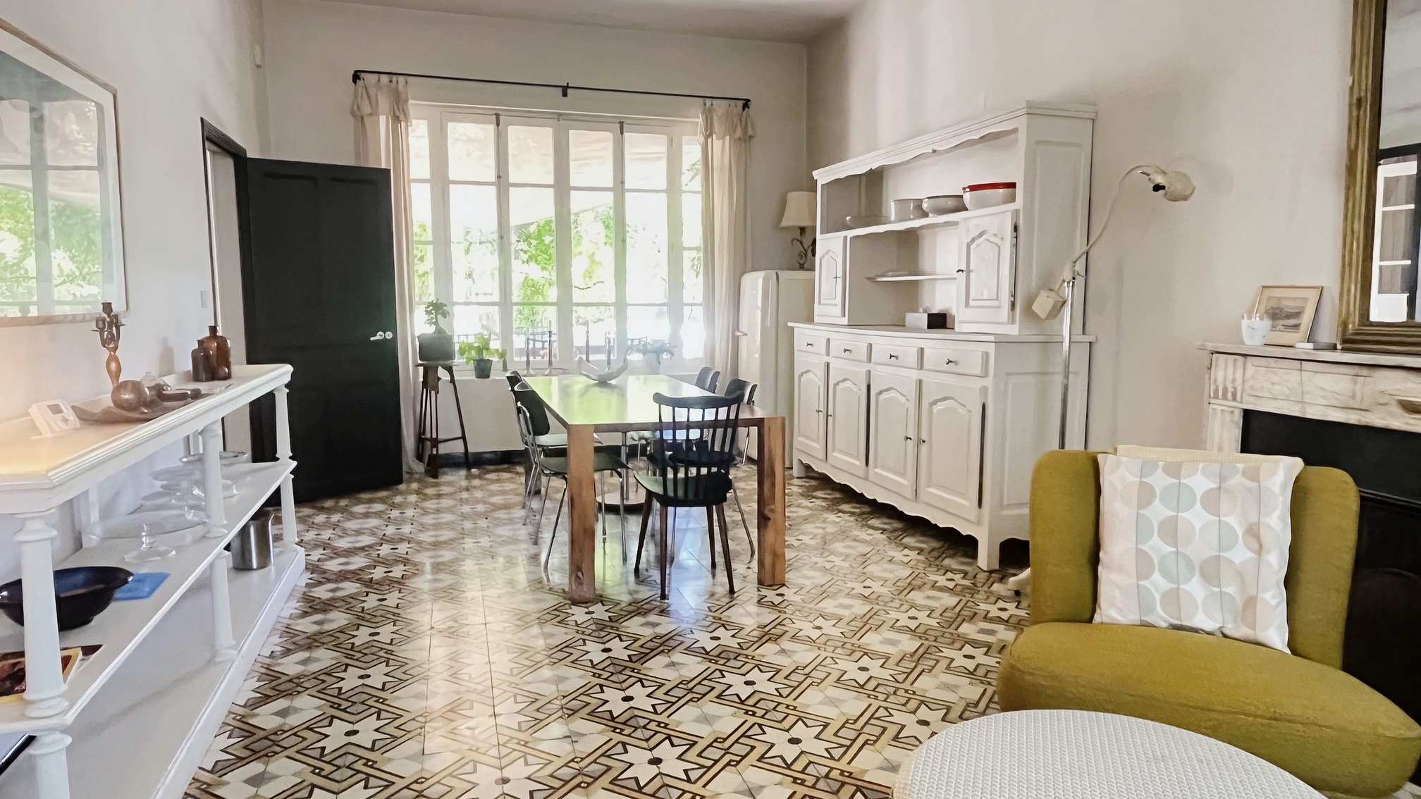 Interior of a renovated bastide with living room, dining room and kitchen, decorative tiling.
