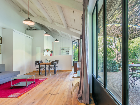 Interior of a renovated country house with living room, dining room and access to a garden.