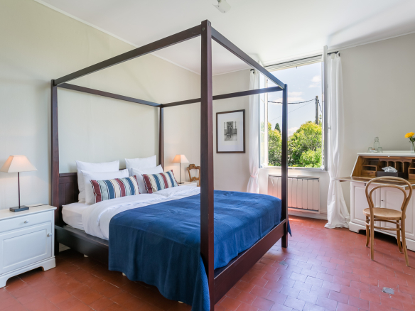 Room in a country house in L'Isle-sur-la-Sorgue with a four-poster bed and desk.