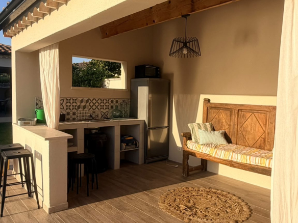 Covered terrace of a modern villa in L'Isle-sur-la-Sorgue, with furniture and kitchenette.