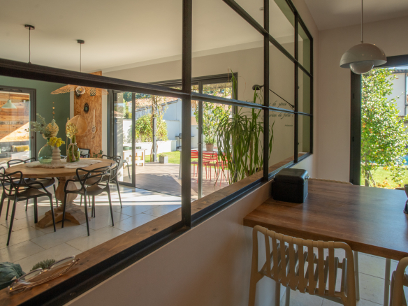 Interior of a modern villa in L'Isle-sur-la-Sorgue with dining room and garden view.