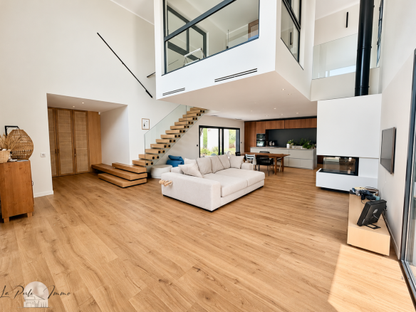 Interior of a contemporary villa with a spacious living room and wooden staircase in Perpignan.