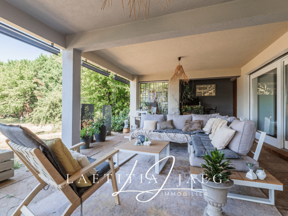 Terrasse spacieuse d'une propriété atypique à Boofzheim avec mobilier extérieur et verdure environnante.