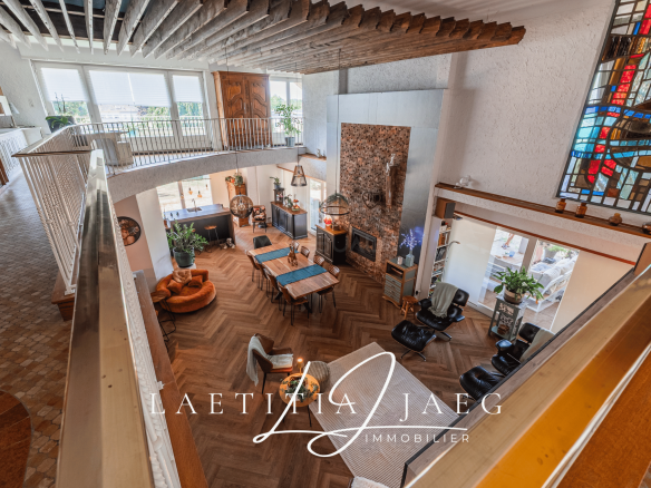 Intérieur d'une propriété atypique avec un grand espace de vie, des meubles modernes et une décoration chaleureuse.