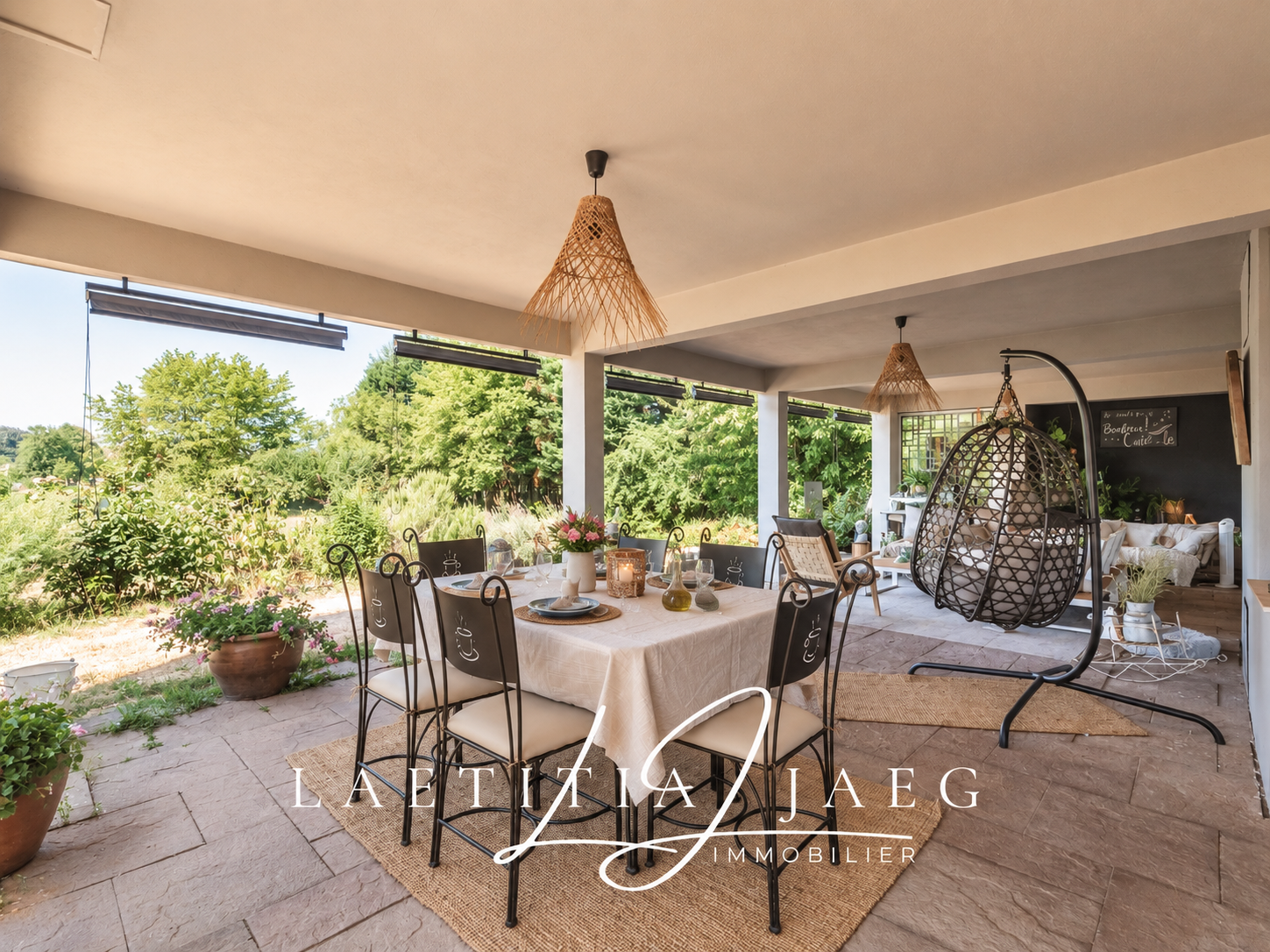 Terrasse d'une propriété atypique à Boofzheim avec table et chaises, entourée de verdure.