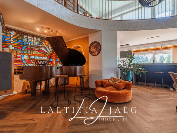 Intérieur d'une maison atypique avec un piano et un salon confortable.