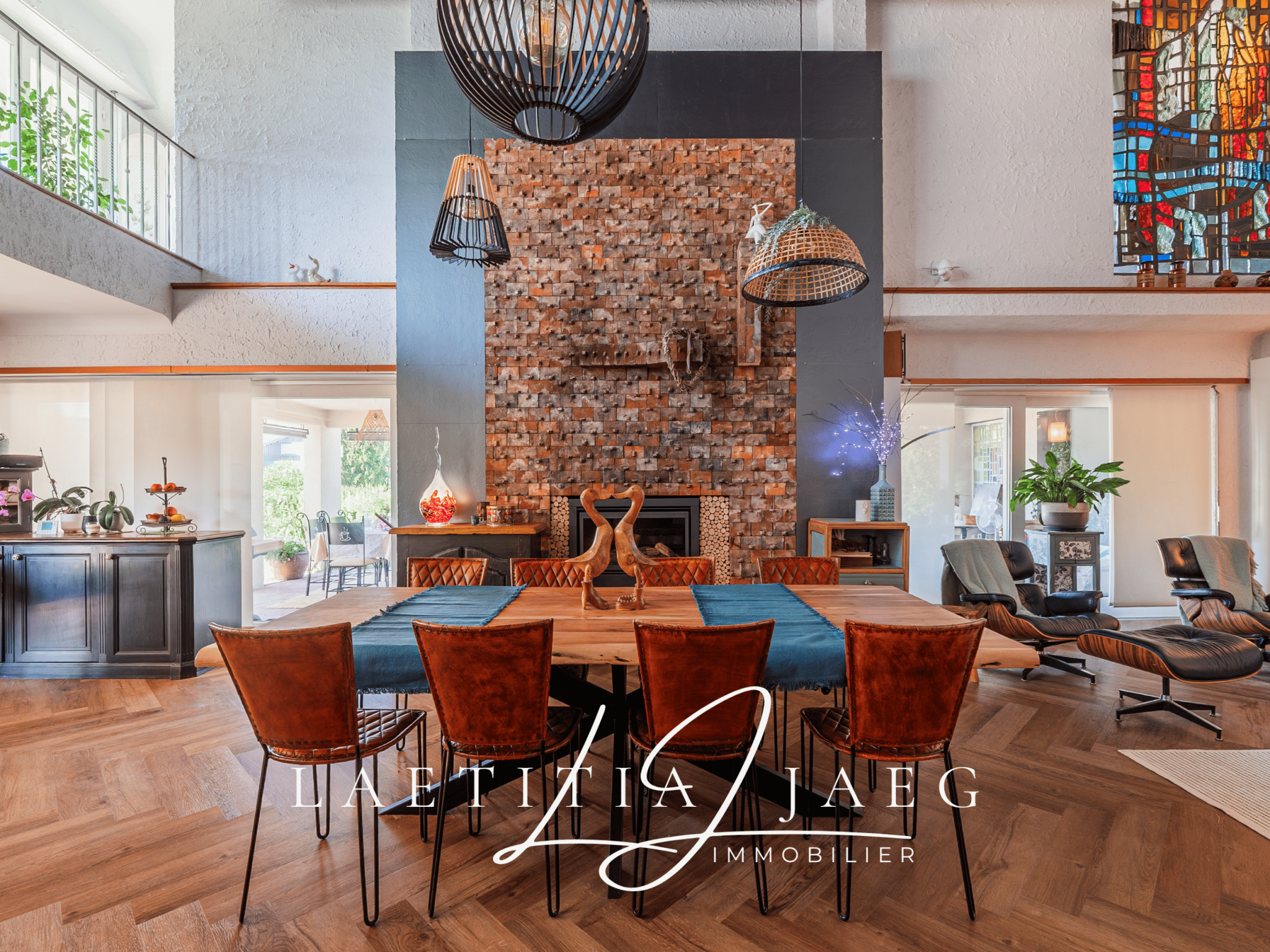 Intérieur d'une maison atypique avec une grande table en bois et un mur en briques.