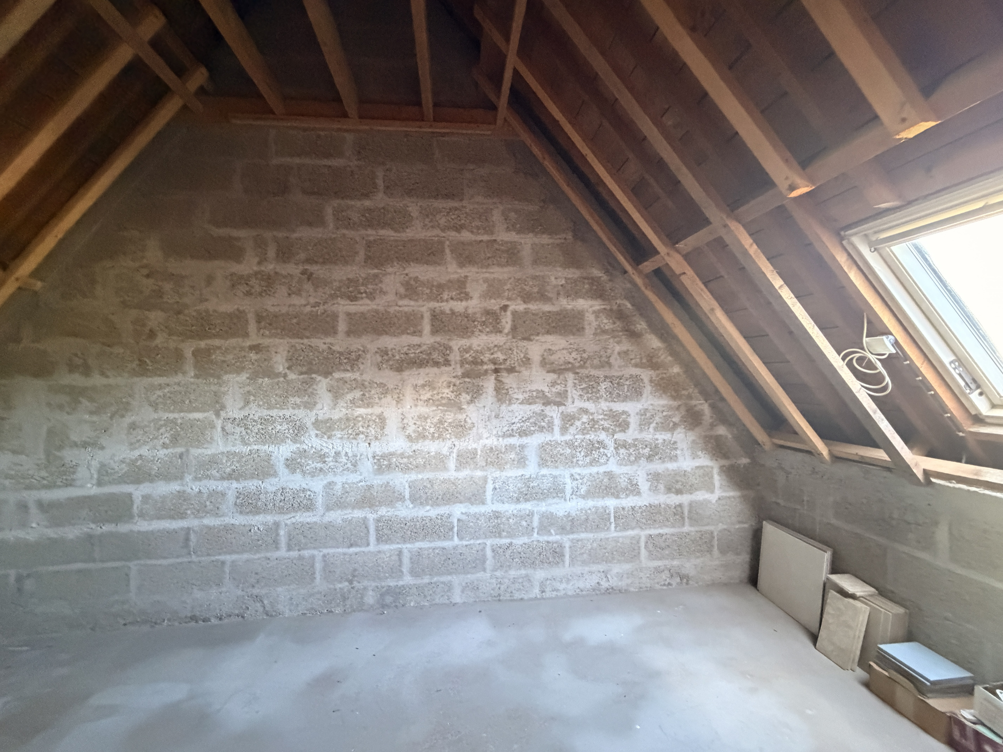 Intérieur d’une pièce à aménager Intérieur d'une pièce avec murs en parpaings et charpente apparente.
