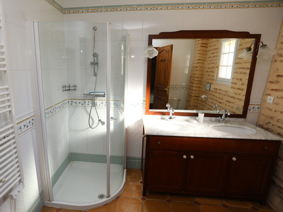 Bathroom with shower, mirror and wooden vanity unit, tiled floor