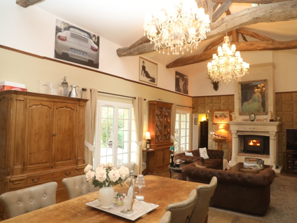 Interior of a house with a large living space, dining table, sofas and fireplace.