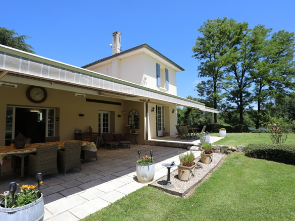 Estate on the banks of the Lot river with main house, terrace and garden.