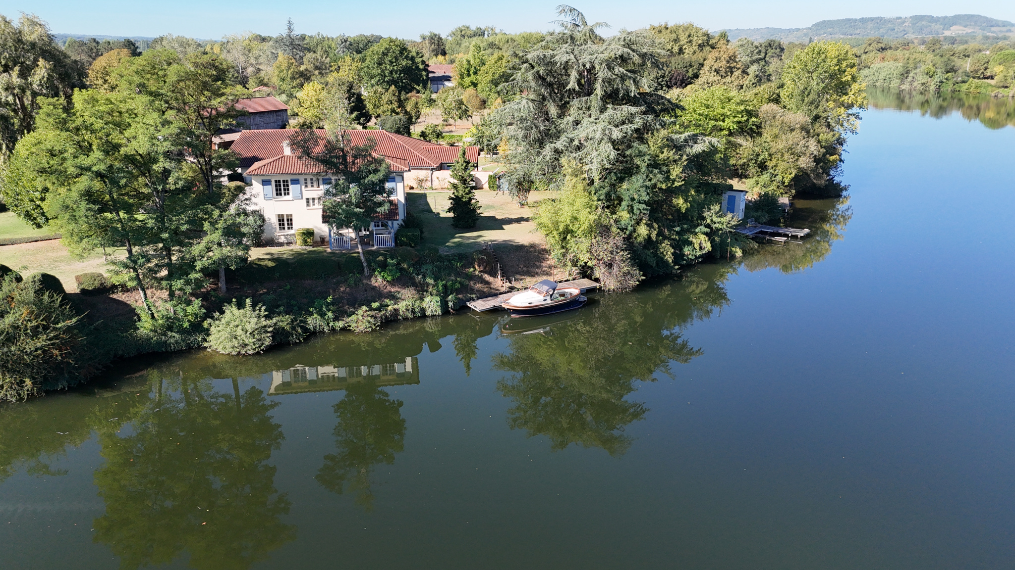Exceptional estate on the banks of the Lot Aerial view of an estate on the banks of the Lot River with three houses, gardens and a swimming pool.