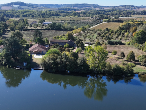 Aerial view of an estate of more than 7 hectares on the banks of the Lot with three houses and green spaces.
