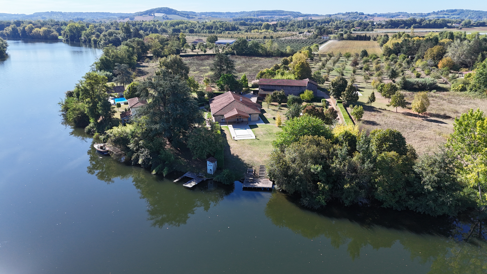 Exceptional estate on the banks of the Lot Aerial view of an estate of more than 7 hectares on the banks of the Lot river with houses and gardens.