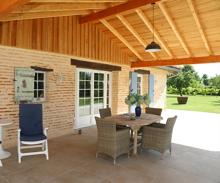 Terrace of the estate overlooking the Lot river Wooden terrace with table and chairs, garden view in an estate on the banks of the Lot river.