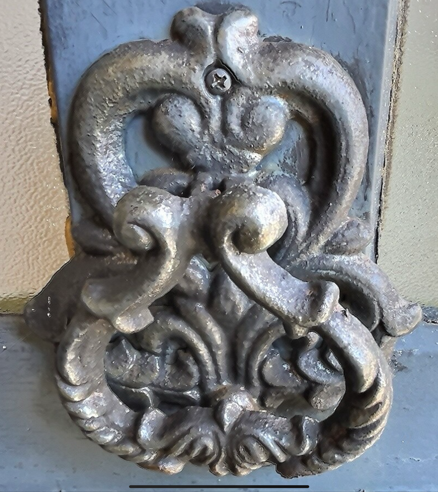 Poignée de porte historique Poignée de porte en métal ornée, style historique, sur un fond de bois.
