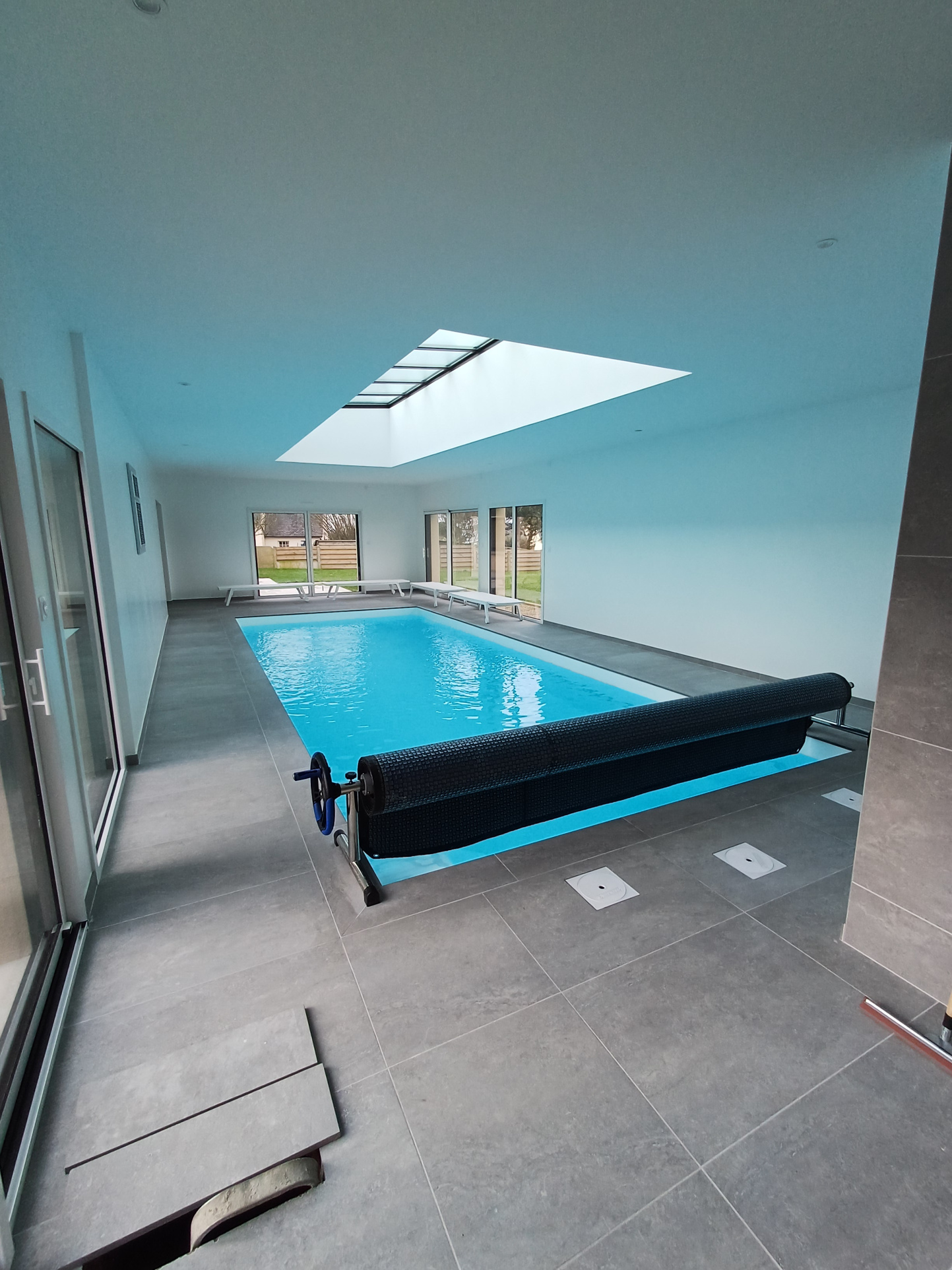 Intérieur moderne avec piscine Intérieur d'une maison avec piscine, murs clairs et grandes fenêtres, éclairage naturel.