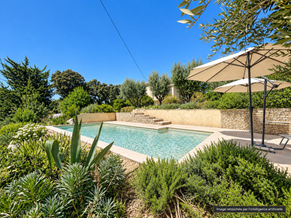 Piscine entourée de végétation méditerranéenne à Vacqueyras, avec vue sur les Dentelles de Montmirail.
