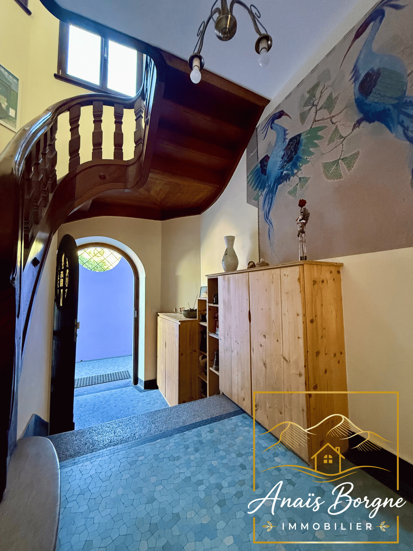 Intérieur d’un manoir d’exception Intérieur d'un manoir avec un escalier en bois et des murs décorés.