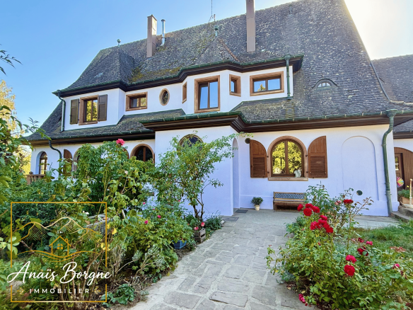 Manoir néo-alsacien avec parc arboré, façade et jardin fleuri.