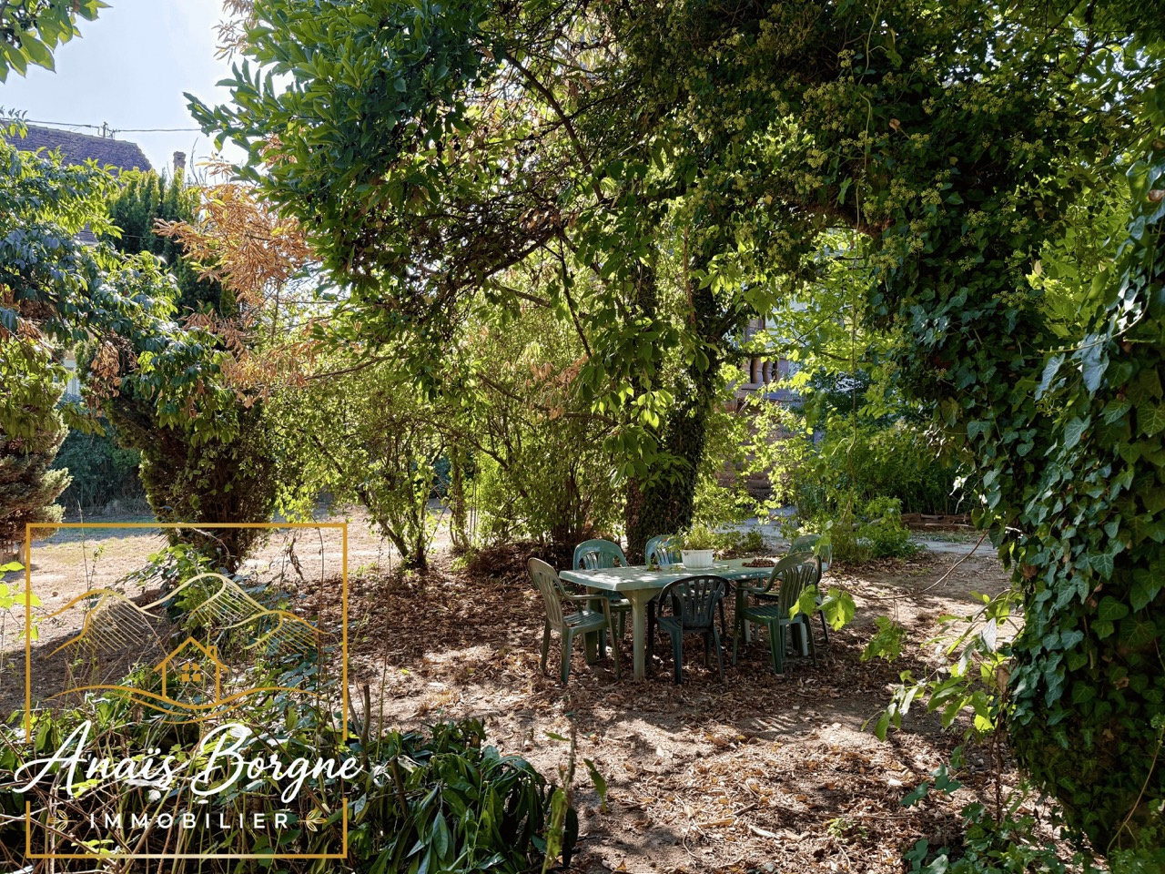 Parc d’un manoir à Villé Parc arboré d'un manoir avec des chaises et une table en plein air, entouré de verdure.