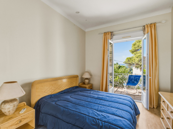 Chambre d'une maison à Saint-Raphaël avec un lit et un balcon offrant une vue.