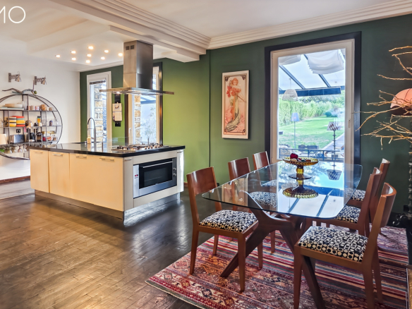 Cuisine moderne avec salle à manger, murs colorés et éclairage naturel, meulière à Arpajon.