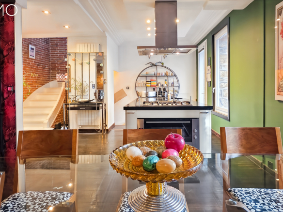Intérieur d'une meulière à Arpajon avec un escalier central et une table décorée.