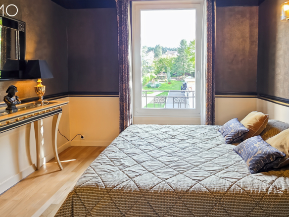 Chambre avec lit double et décoration élégante, vue sur le jardin à Arpajon.