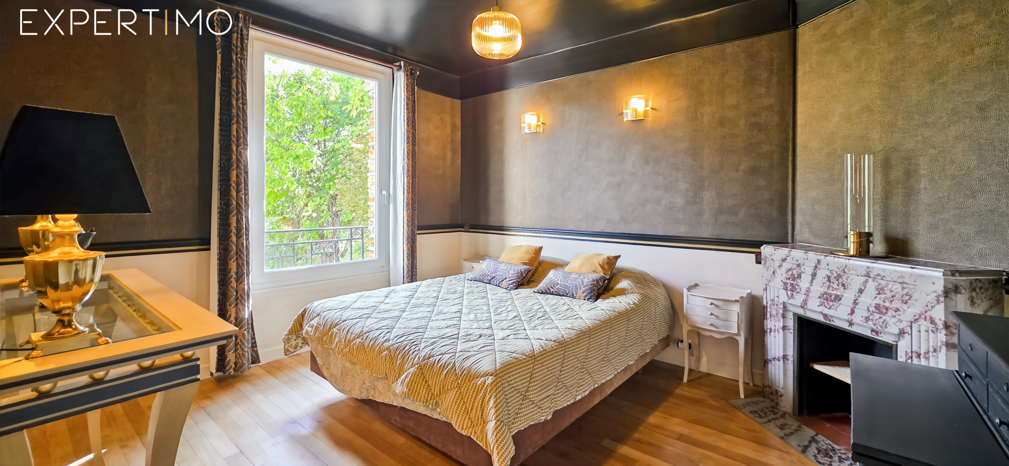 Chambre d’une meulière à Arpajon Chambre d'une meulière à Arpajon avec lit, cheminée en marbre et fenêtres donnant sur l'extérieur.