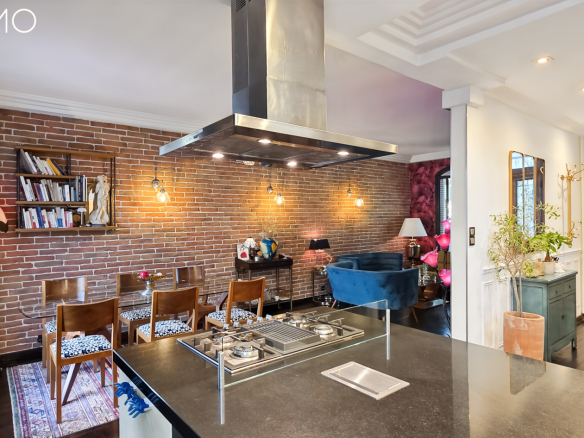 Intérieur d'une meulière à Arpajon avec cuisine moderne et mur en briques apparentes.