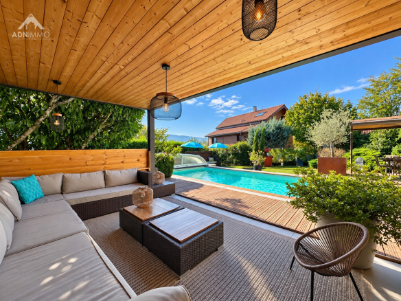 Terrasse d'un chalet avec salon extérieur et piscine, entourée de verdure à Crozet.