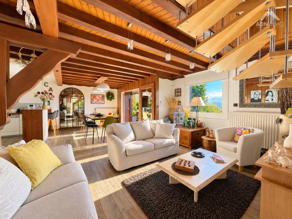 Intérieur d'un chalet rénové de 158 m2 avec salon lumineux et vue sur la nature.