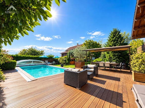 Chalet avec piscine et terrasse en bois, entouré de verdure à Crozet.