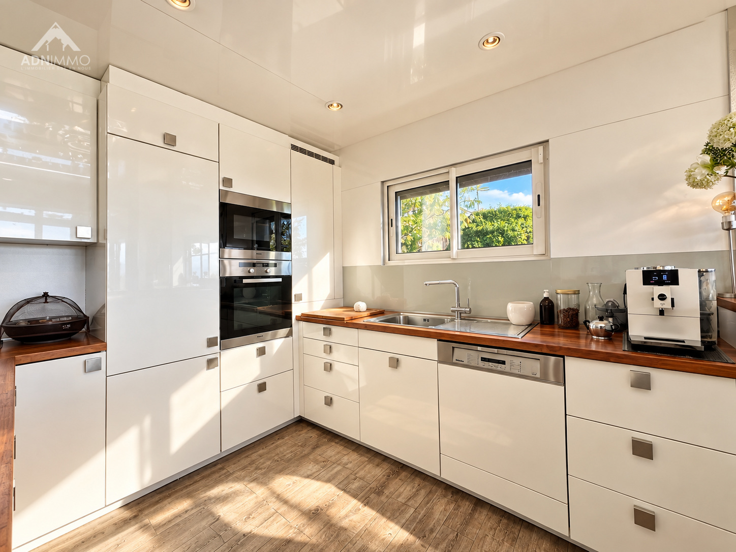 Cuisine moderne et lumineuse d'un chalet à Crozet, avec des meubles blancs et un plan de travail en bois.