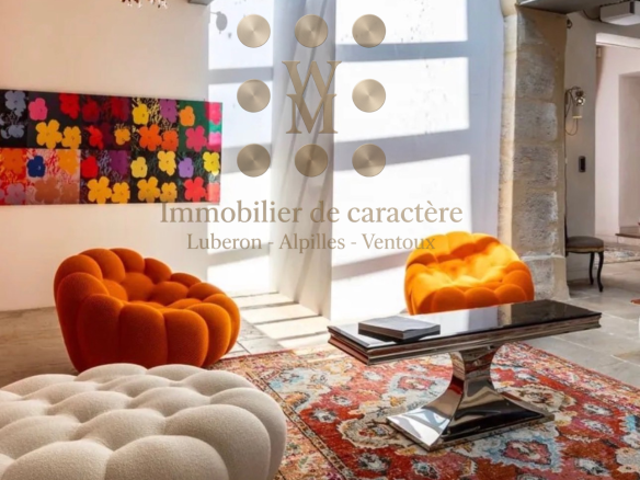 Interior of a modern property with colorful armchairs and a traditional style rug.