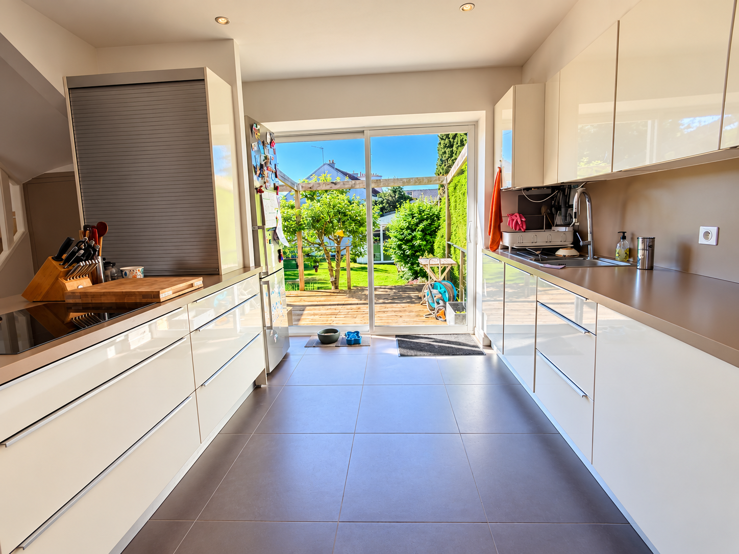 Cuisine avec vue sur le jardin Cuisine moderne avec accès à un jardin, lumière naturelle abondante.