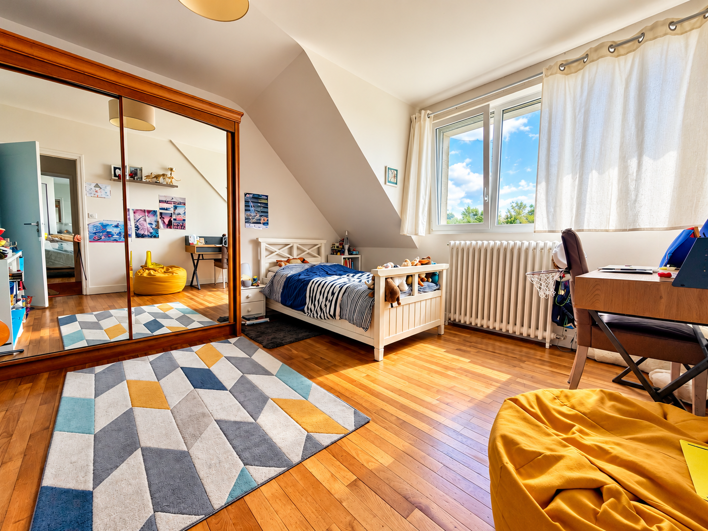 Chambre à Auray Chambre lumineuse avec parquet en bois, lit simple, miroir et bureau, fenêtres avec vue sur le ciel.