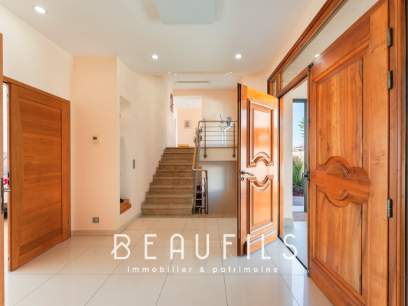 Intérieur d'une villa à Sète avec une entrée spacieuse et des portes en bois.