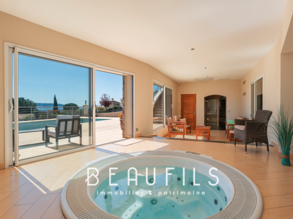 Intérieur d'une villa avec jacuzzi et vue sur la piscine.