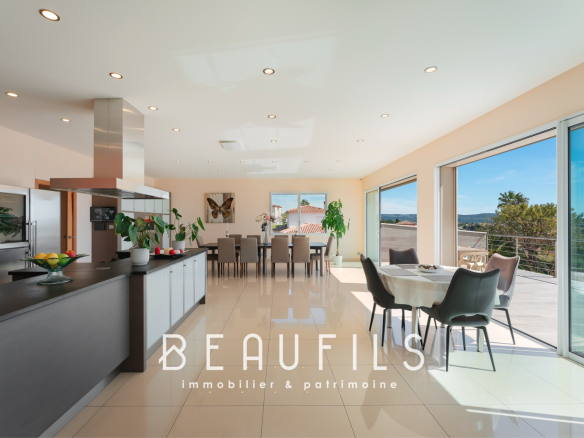 Intérieur moderne d'une villa avec cuisine ouverte et vue sur la nature.
