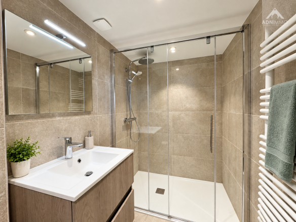 Salle de bain moderne avec douche à l'italienne et meuble vasque en bois.