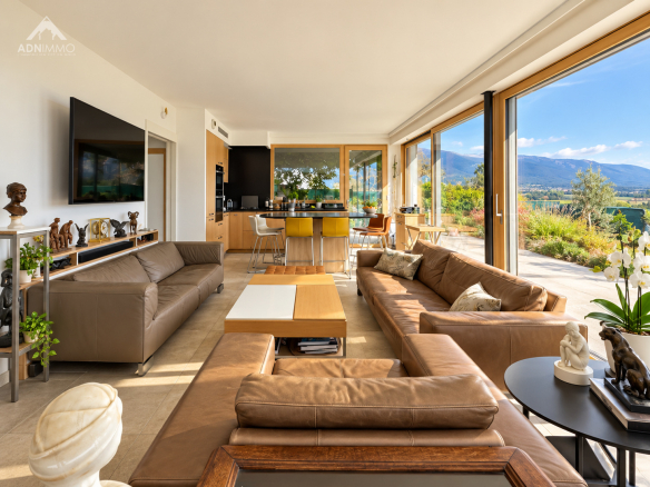 Intérieur d'une maison moderne avec salon spacieux et vue sur la nature.