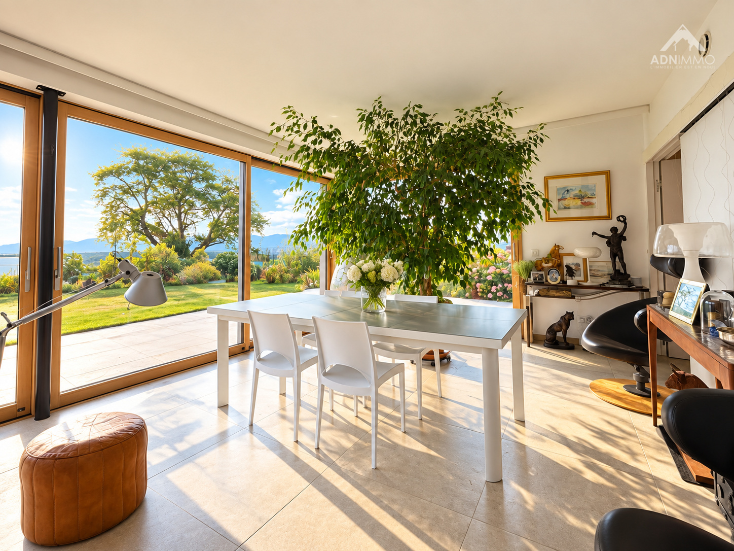 Intérieur d'une maison rénovée avec une grande table à manger et une vue sur le jardin.