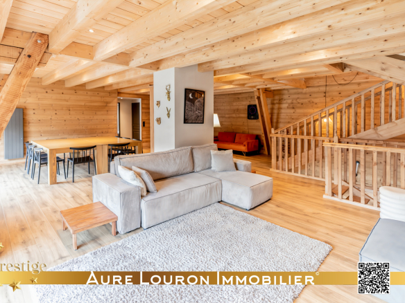 Intérieur d'un chalet en bois avec salon, salle à manger et mezzanine.